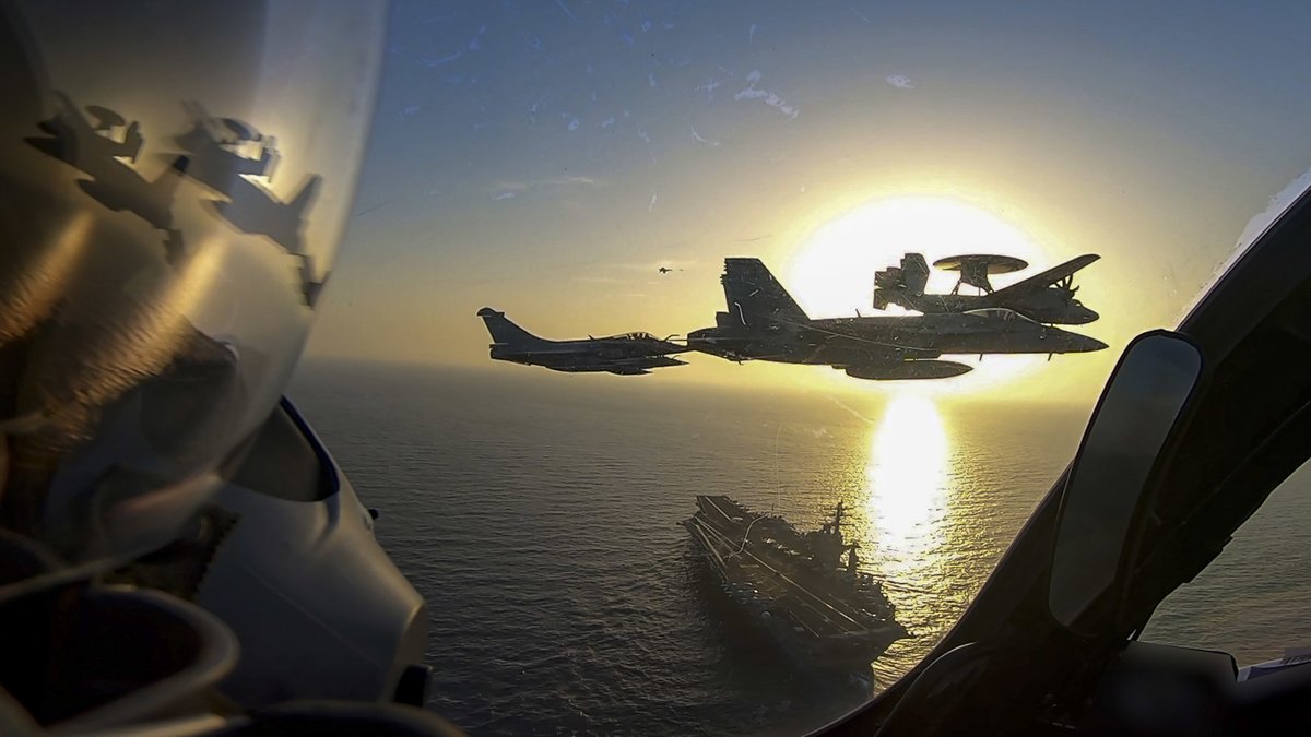 French Navy Rafales, a US Navy F/A-18 & either a French or US E-2 Hawkeye flying over the USS Eisenhower as part of the Clemenceau 21 deployment.

(French Navy Photo)