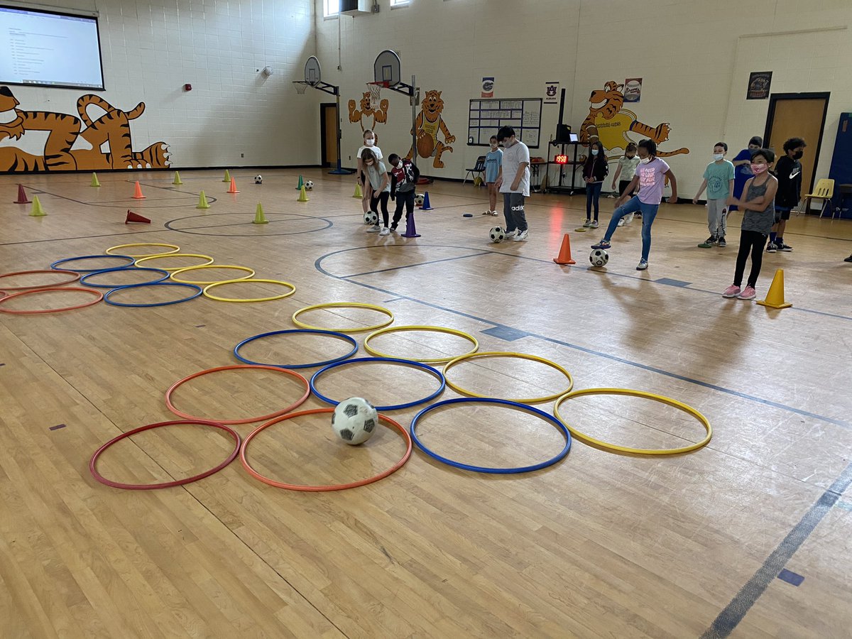 NFSoftballCoach's tweet image. Soccer Skee-Ball! Dribble to the cone. 1 point for landing in the yellow hoop. 2 points for blue. 5 for orange. 10 for the small red hoop! @ManningOaksFCS @OPENPhysEd @HollyMarzetti Everyone gets 3 chances. Team with most points wins!