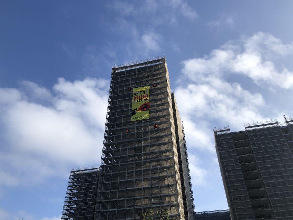 Greenpeace's tweet photo. Happening now! Activists have scaled the building facing the @eni HQ in Rome on the day of their AGM, to shine a light on the greenwashing of Italy's biggest polluter. 

It's time to go fossil free!

#fossilfreerevolution #lebugiedieni https://t.co/JSPGAmLkoK