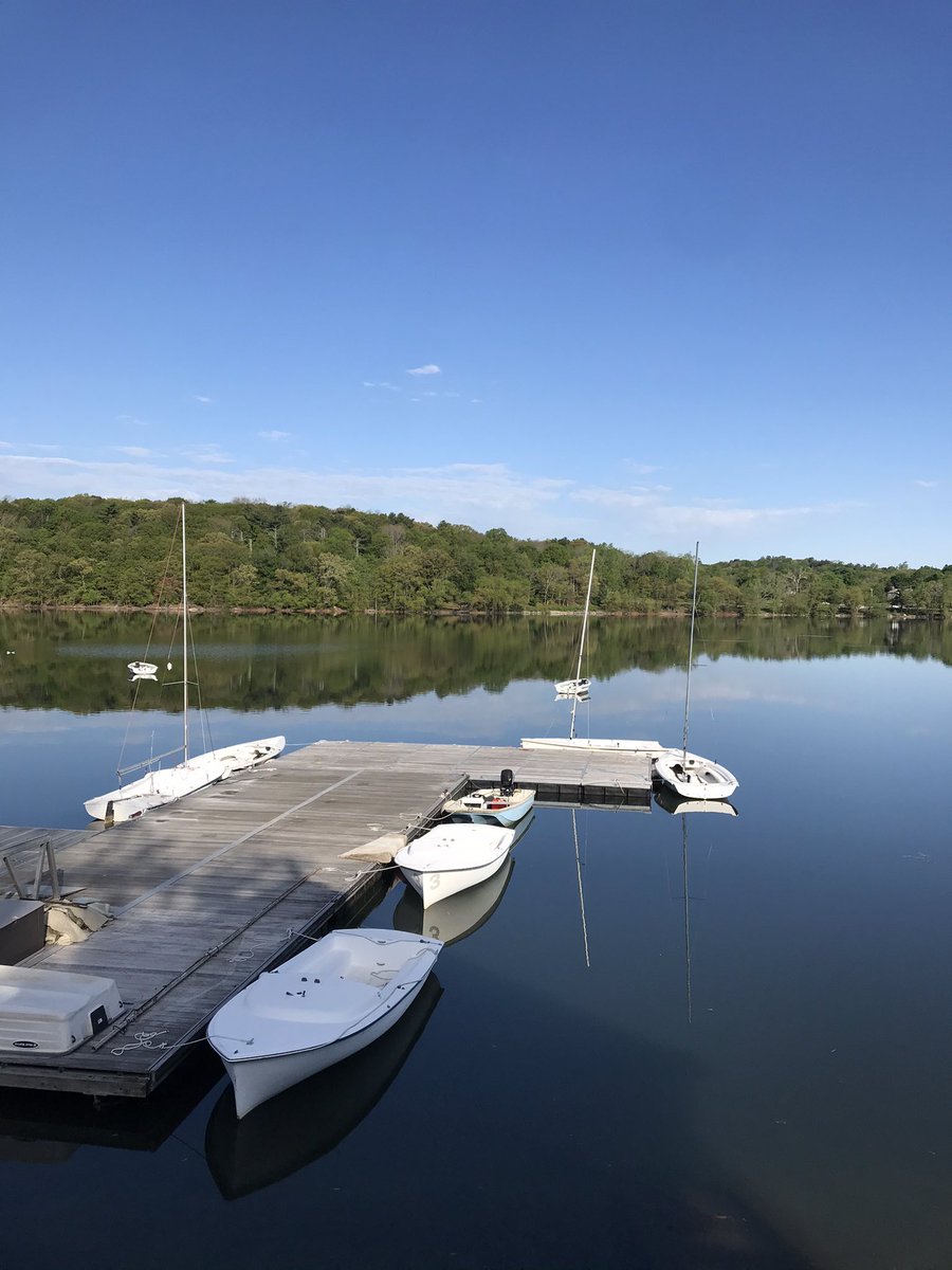 Jamaica Pond on a sunny morning, white boats floating by boardwalk