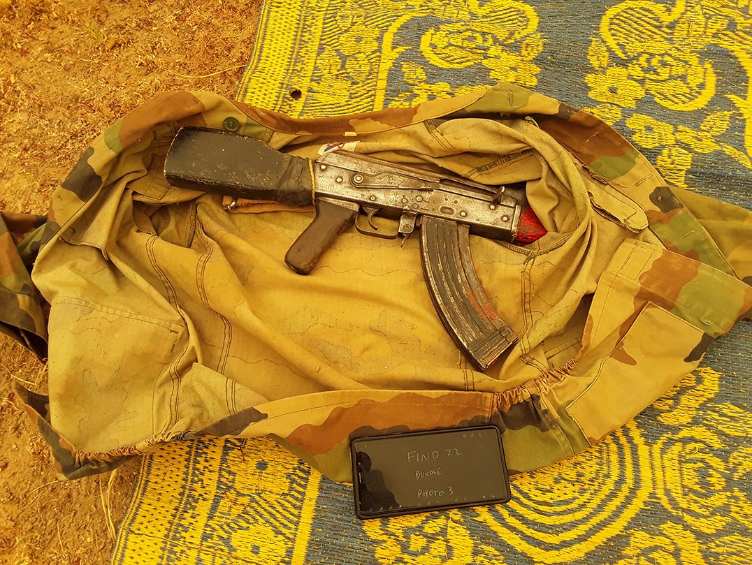 An AK47 rifles wrapped in a camouflage jacket lies on the floor after being discovered hidden.