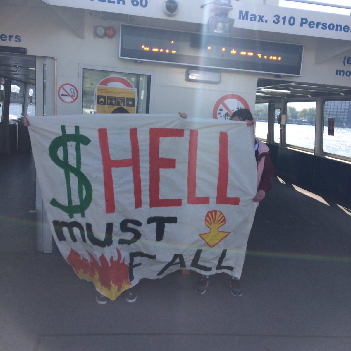 ForFutureAdam's tweet photo. We doen bannerdrops op de pont naar Noord! #ShellMustFall https://t.co/lhUzflmBEk