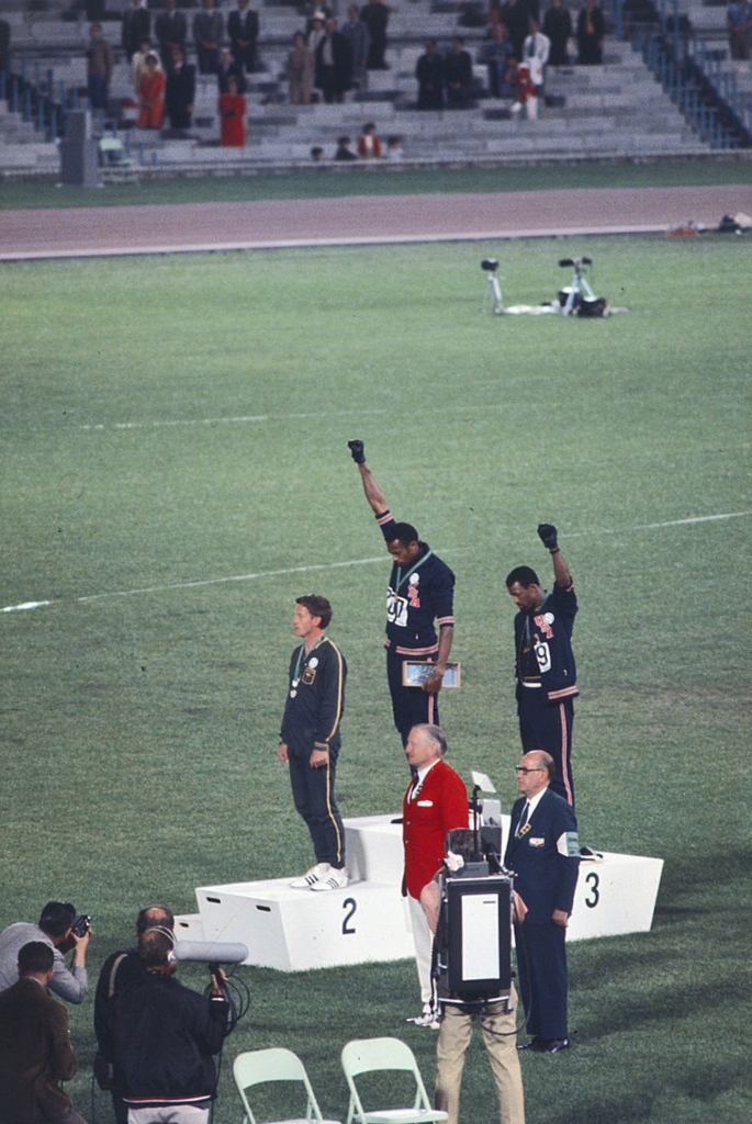 ブゥニィ ブゥ 1968年メキシコシティ 陸上男子0mを世界新で制したトミー スミスと3位のジョン カーロスは 掲げた拳の黒手袋に人種差別への抗議を示し 選手村から追放された オリンピック憲章は 選手の政治的パフォーマンスを禁じている なのに