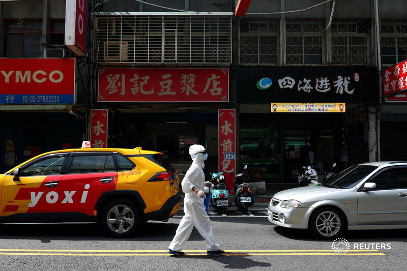 A person dressed in a protective suit walks down a street in Taipei amid Taiwan's coronavirus outbreak. More photos of the day: reut.rs/3fJsfBb 📷 <a href="/annwphoto/">Ann Wang</a>