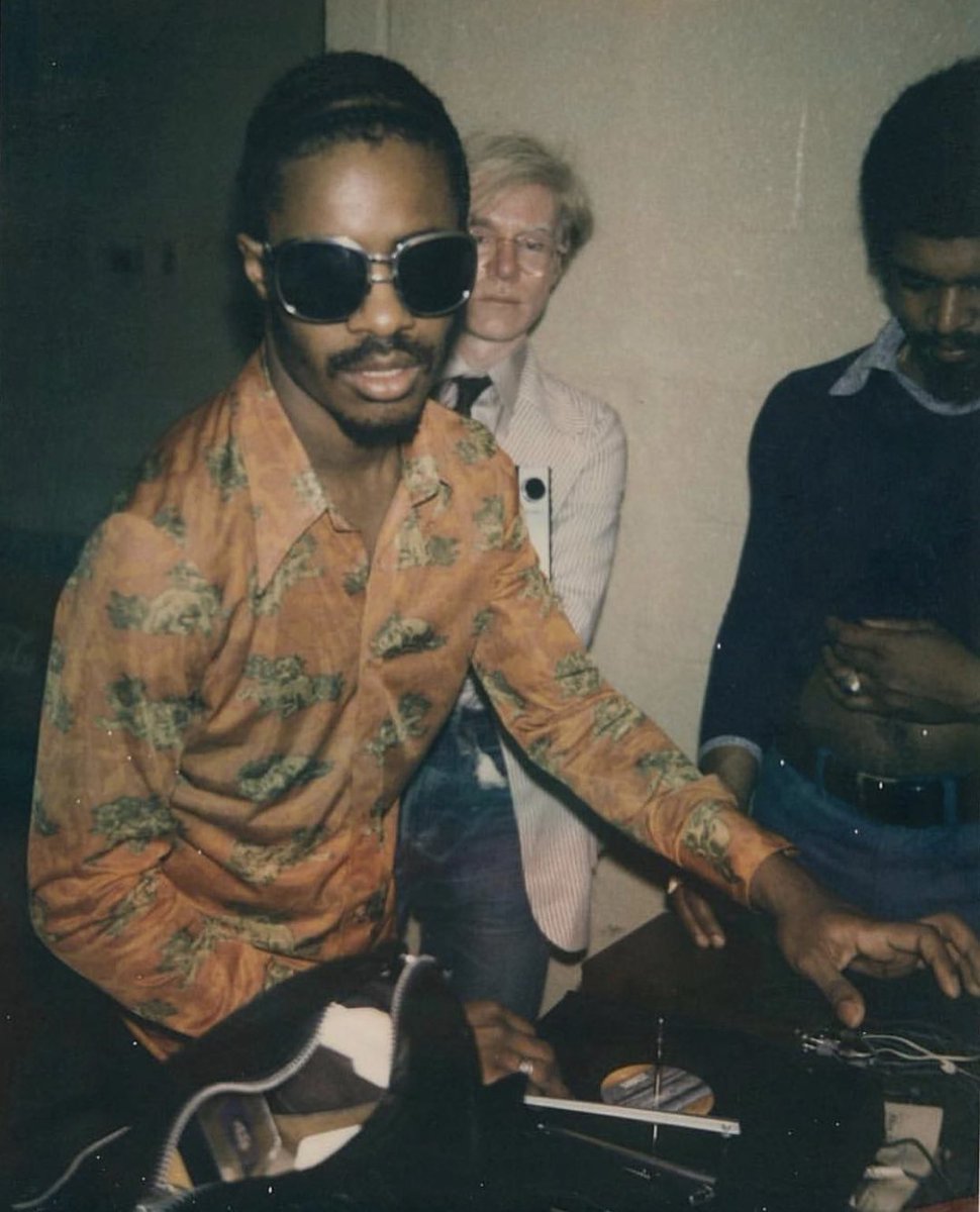 DefectedRecords's tweet photo. Stevie Wonder playing some records with Andy Warhol &amp; Gil Scott-Heron hanging out backstage at a @RollingStones concert, LA 1972 💯 https://t.co/c5qX8OFFLu
