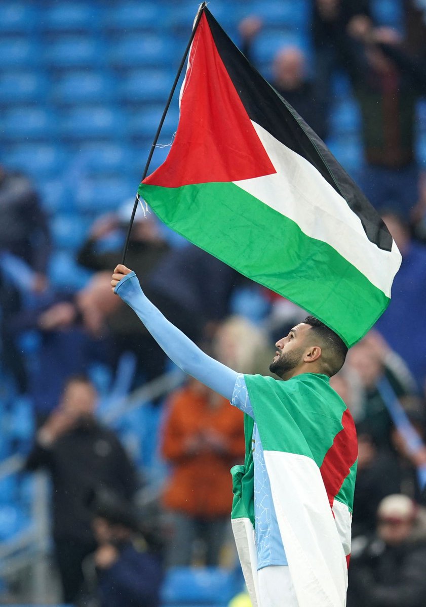 TRTArabi's tweet photo. لاعب مانشستر سيتي رياض #محرز يرفع علم #فلسطين متلحفاً بعلم بلده الجزائر خلال تتويج الفريق ببطولة الدوري الإنجليزي https://t.co/SsDPPE1wBh