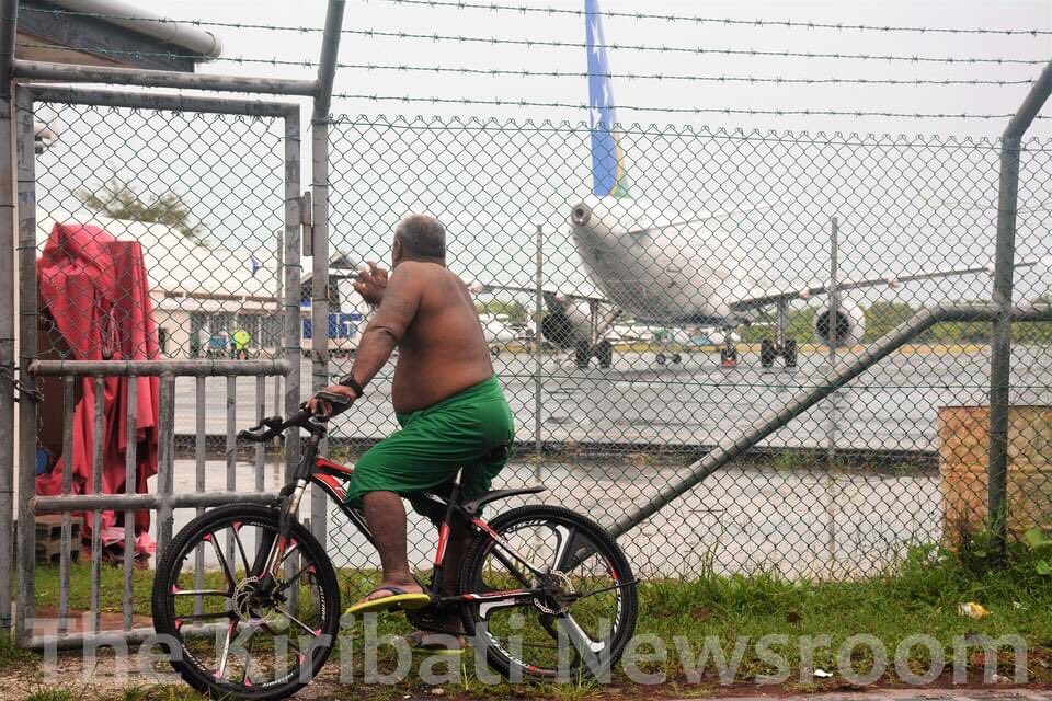rmrimon's tweet photo. A villager in Bonriki stops from his commute to watch a Solomon Airlines flight that arrived in Kiribati this afternoon with AstraZeneca vaccines for 20% of the 118,000 Kiribati population https://t.co/brBKkBBbu5