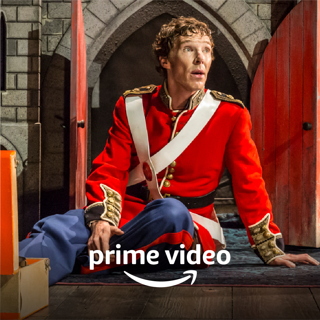 A man with light brown hair in a stately red and gold uniform sits aghast by a small open door. Prime Video logo.