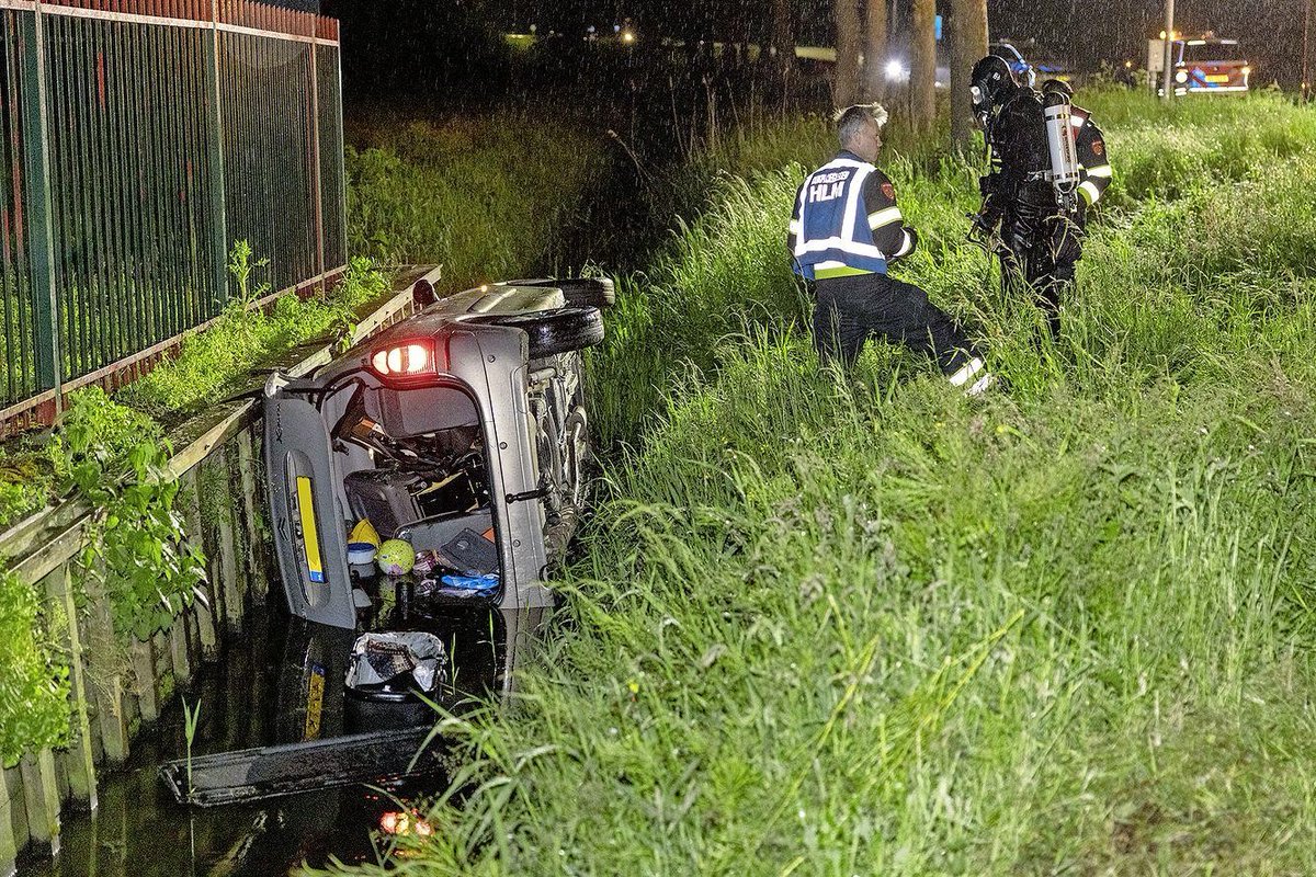 Auto belandt op zijn kant in de sloot bij ongeval in Vijfhuizen; duikers zoeken naar bestuurder..