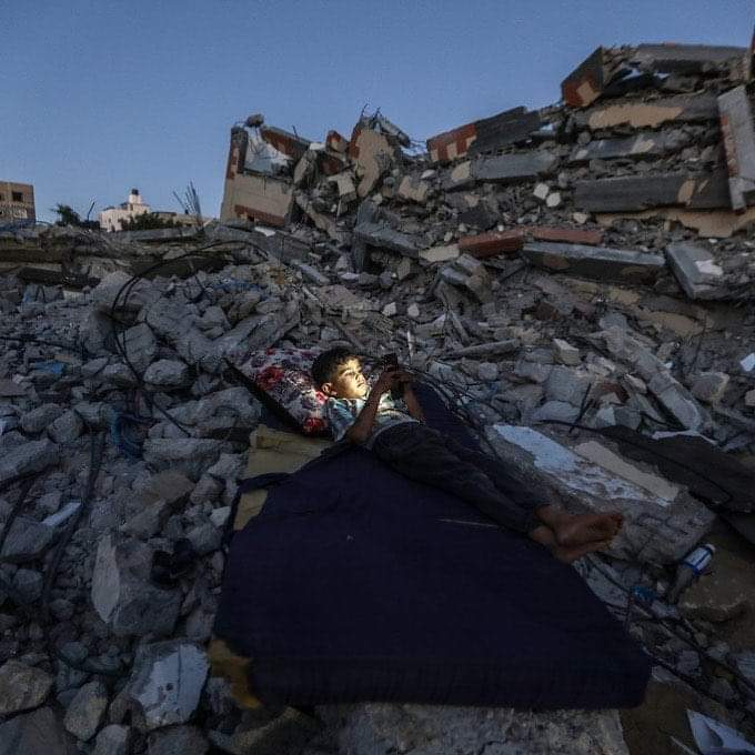 AyaIsleemEn's tweet photo. A Palestinian child lays on a mattress over the rubble of his destroyed house, which was bombed by Israeli warplanes occupation during the recent aggression on Gaza. https://t.co/aRn250F7Ii