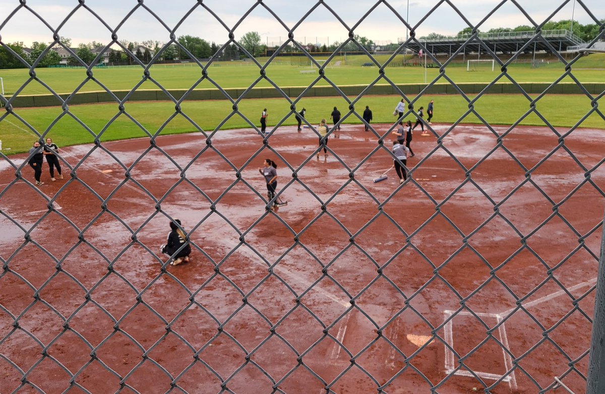 KendraPingel's tweet photo. When life gives @Sabres_Softball rain, it's senior night and they really want to play. The team works together to get the water off the field. #SabrePride #weareshs https://t.co/Qr04r7P7Em