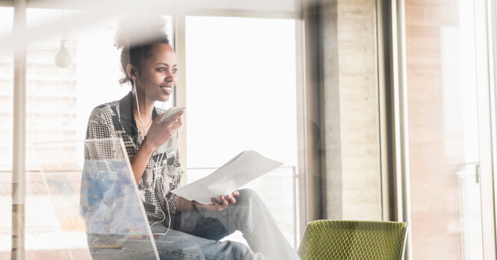 Girl smiling while holding documents and on a phonecall 