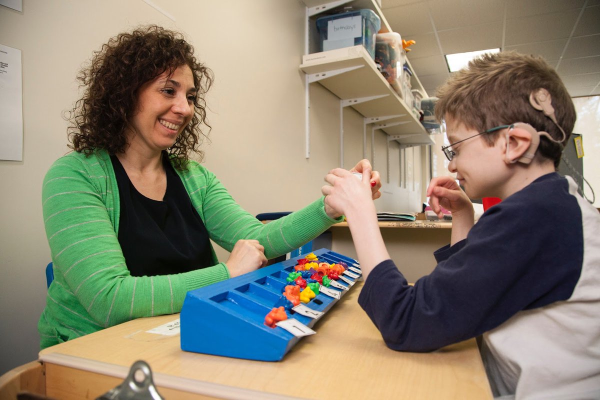 A special education teacher works on a counting activity with a boy with visual impairment.