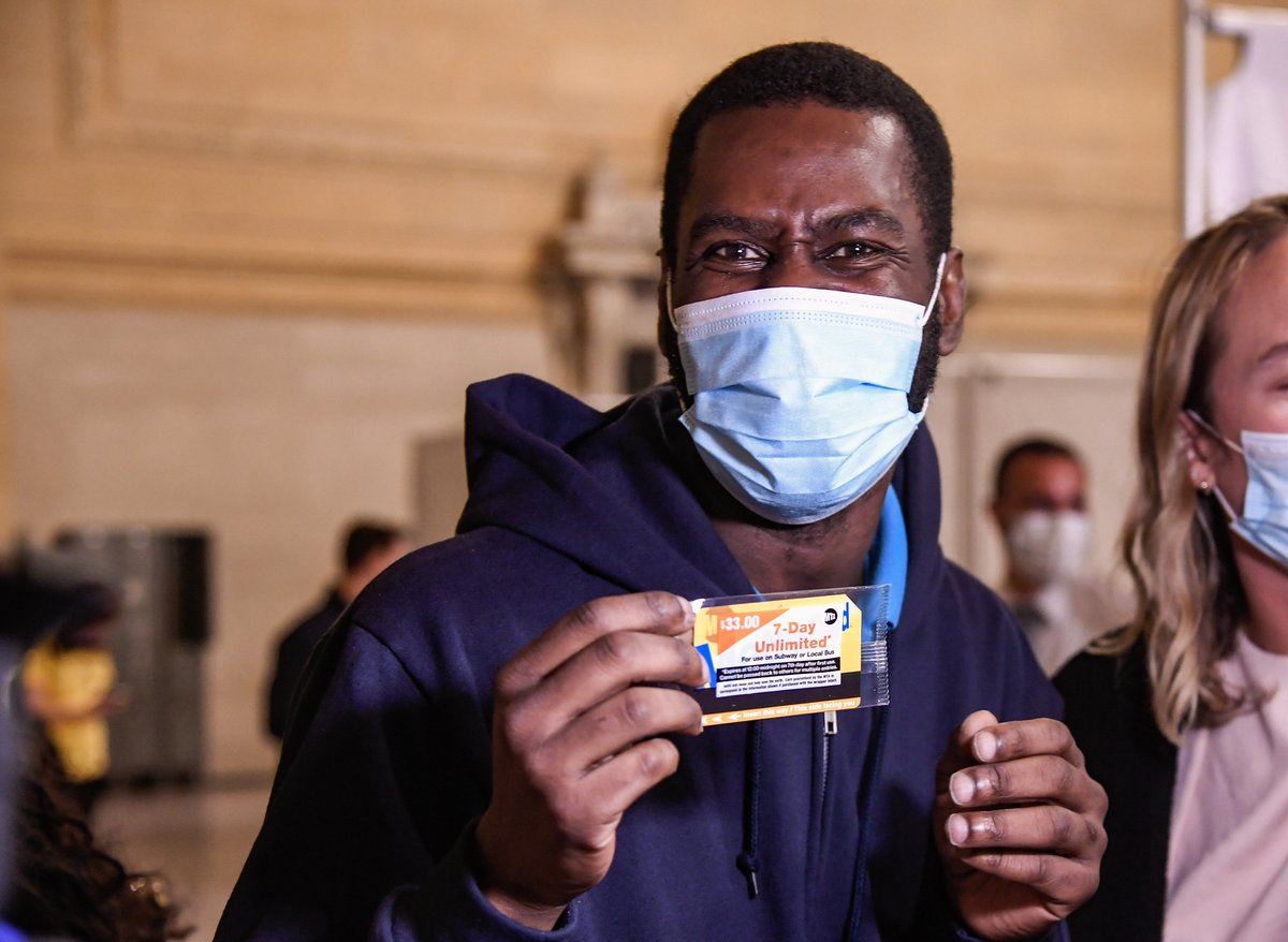 Person holding a 7-day MetroCard