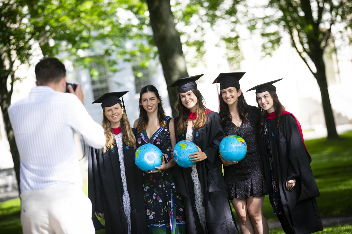 Graduates holding globes pose for a photo