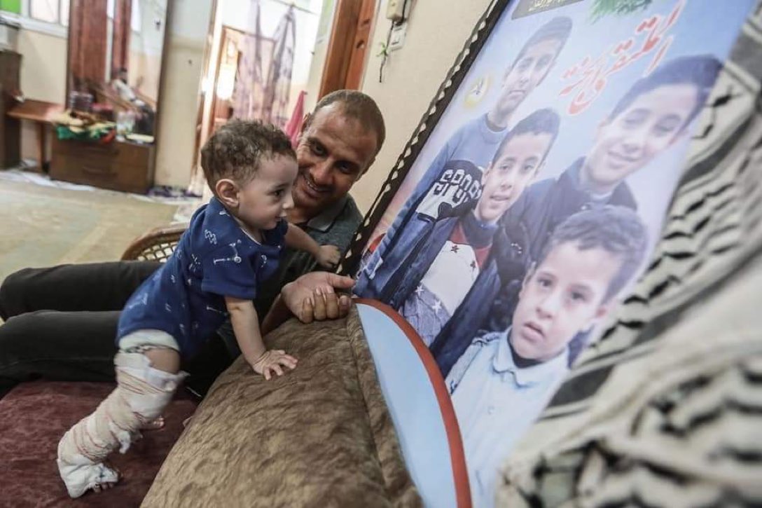 swilkinsonbc's tweet photo. Palestinian toddler, Omar Alhadeed, the only survivor of his family, looks at a photo of his brothers, killed by the israeli attack on #Gaza https://t.co/ycruUzYaa0