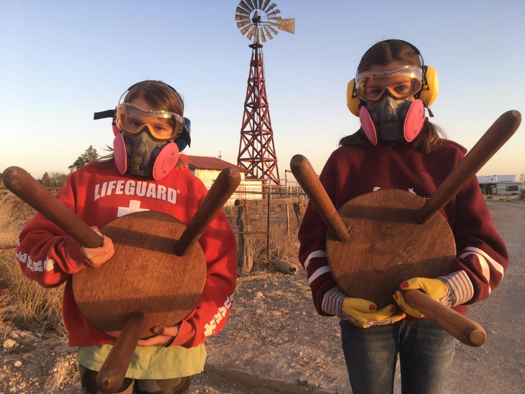 Members of the lumber club in Marfa, Texas, display their handmade three-legged stools. 