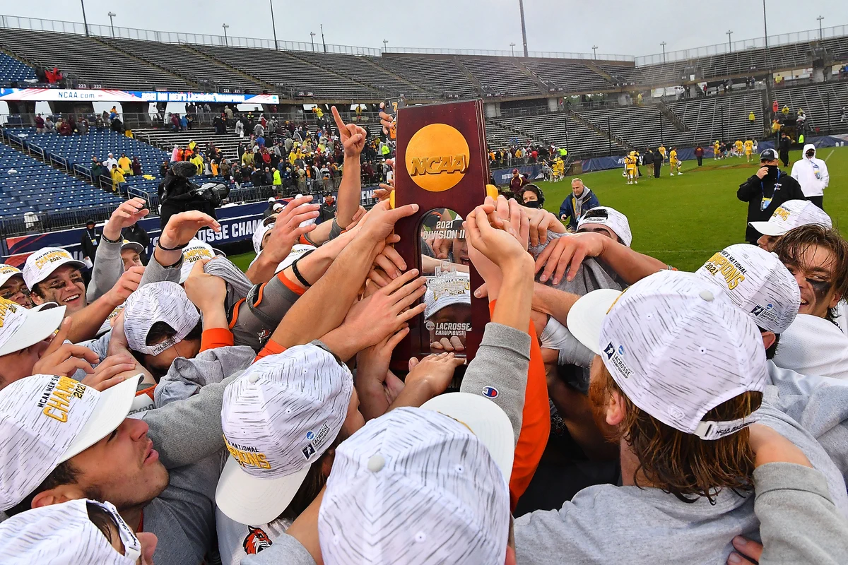 RIT players hold up the national championship trophy 