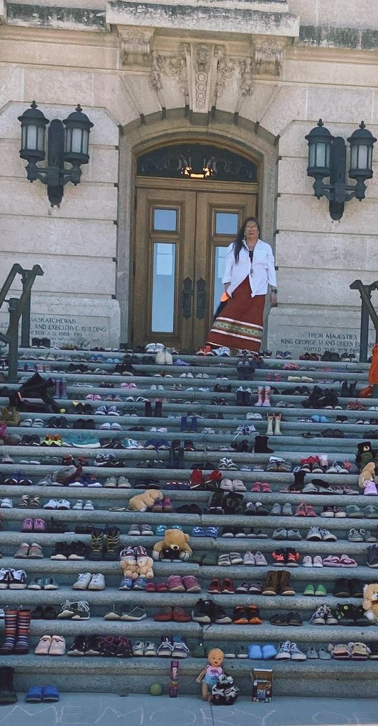 Mom at the ledge in Regina today, 215 pairs of children's shoes in memory of them. #215children