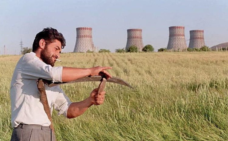 armenianvisuals's tweet photo. Man sharpens his scythe before cutting a field of grass next to the Armenian nuclear power station 1995 https://t.co/o55gqigpWg