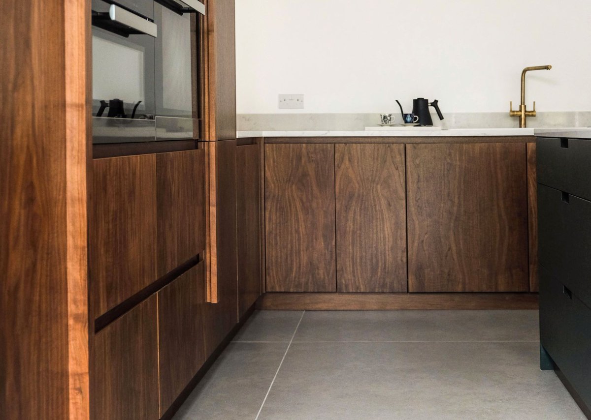 This kitchen uses striking walnut alsongside our deep green 'Sandringham Pine' painted cabinetry. Our Midgard handle design on the island adds a beautiful, practical sense of Scandi style. #NakedKitchens #TrulyBritishTrulyBespoke