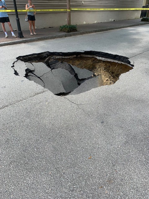 CharlestonPD's tweet photo. Coming Street is closed at Bull Street due to a sinkhole that caused a section of the road about ten feet in diameter to collapse. The hole is about eight feet deep. Traffic is being diverted west on Bull Street, No injuries resulted from the collapse. 
#chsnews #chstrfc https://t.co/Xh5sMOWHp5