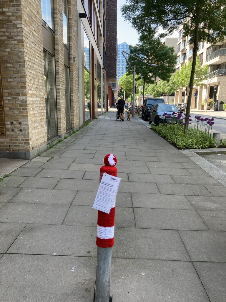 Poller mit Mütze auf dem Gehweg am Kaiserkai, Hafencity. Im Hintergrund die Elbphilharmonie