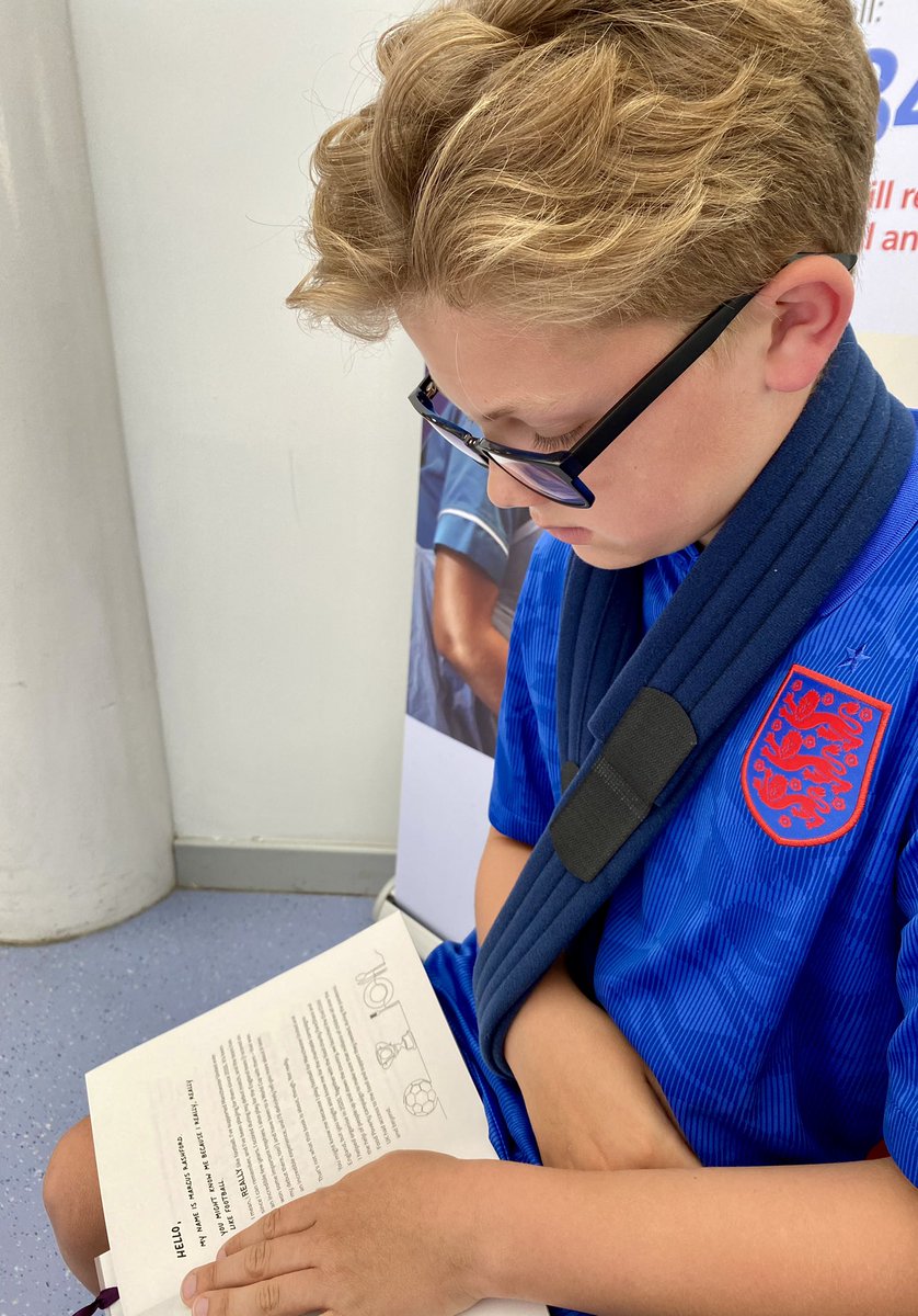 My 10 year old broke his collarbone playing football yesterday, we’re back at the fracture clinic to see if he needs an op...he’s passing the time by starting @MarcusRashford’s #YouAreAChampion wearing his England shirt 💙⚽️ 📖