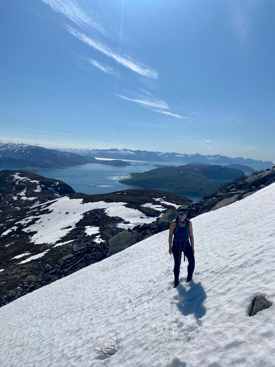 Me hiking in the mountains with fjord in background, little snow left.