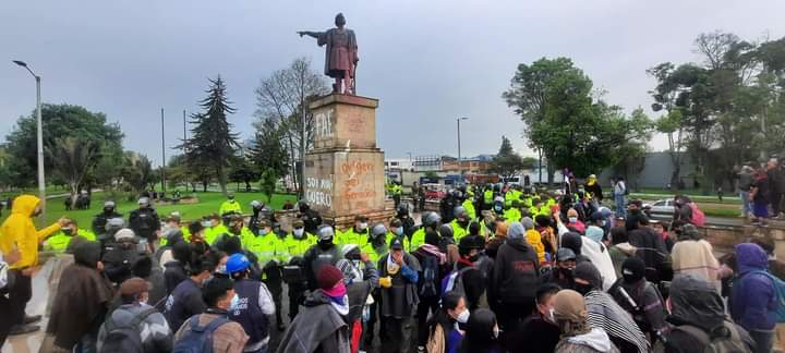 Hekatombe_'s tweet photo. Gran cantidad de Fuerza Disponible de la Policía está custodiando la estatua de Cristóbal Colón de la calle 26 con carrera 98.

En este punto convocó concentración el Pueblo Misak. La Fuerza Pública está lanzando gases lacrimógenos.

Foto de AISO.

#ParoNacional9J https://t.co/21vOdcEC5b