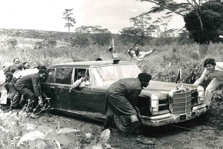 Kenyans's tweet photo. Jomo Kenyatta motivating his staff as they push his Mercedes Benz that got stuck in the mud. #KenyansTBT https://t.co/cGkTA5Y1gF