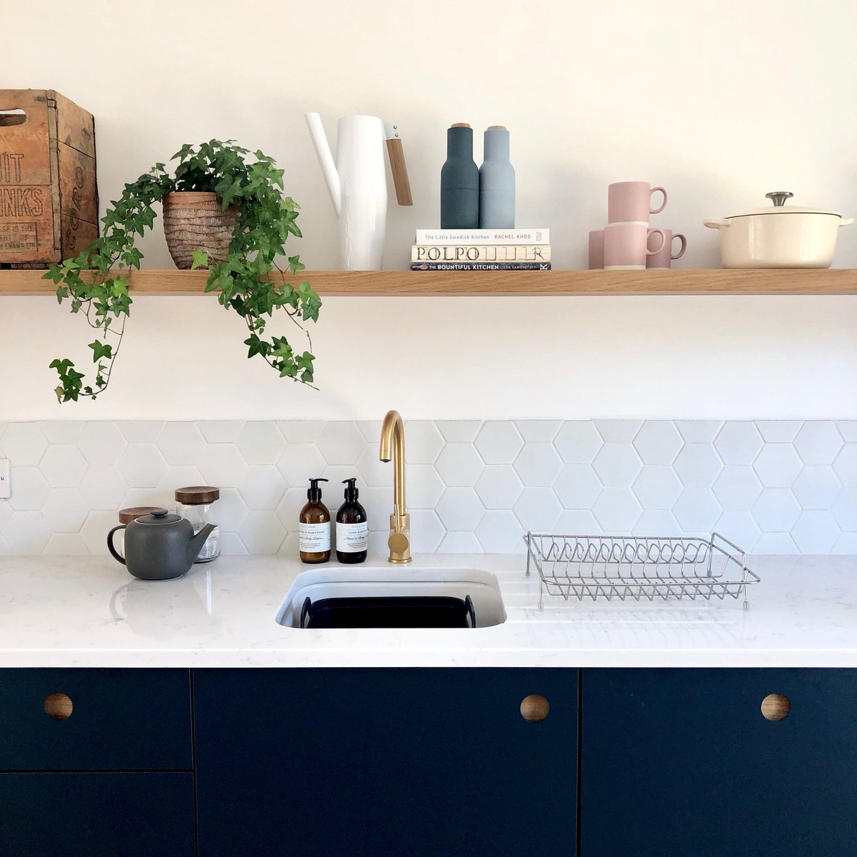 A deep-blue kitchen with Ladbroke doors look stunning with a white marble worktop and white tiled splashback. It is the perfect kitchen style for a costal property! Interior design @kinship_creativedc Image @thedunnsorford #NakedKitchens #TrulyBritishTrulyBespoke