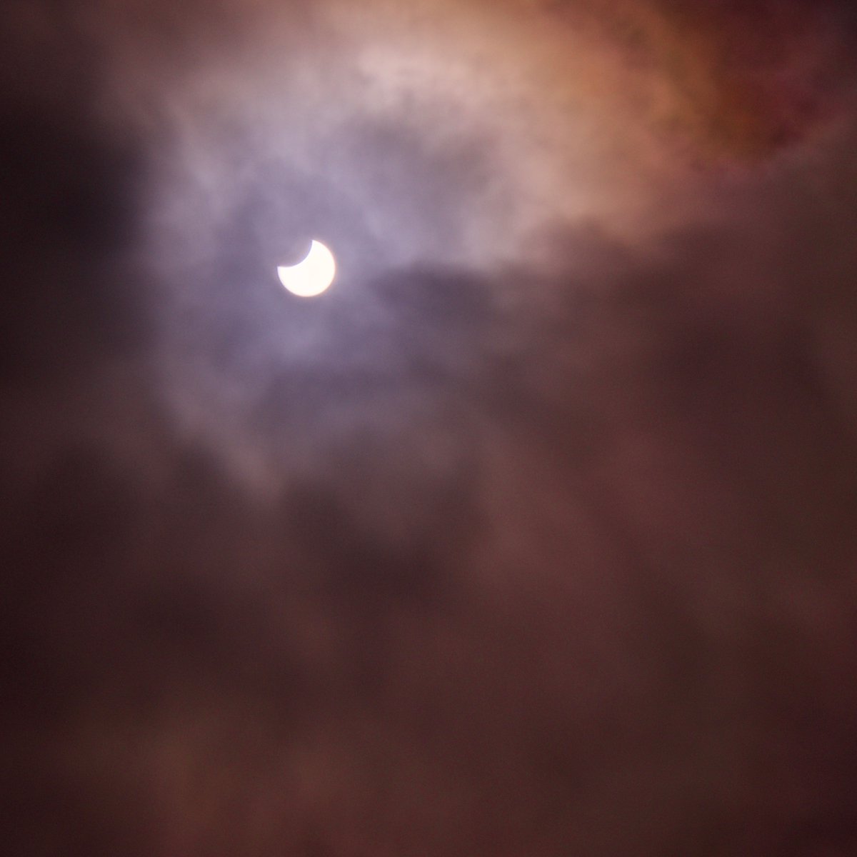 Some breaks in the cloud allowed a good view (&amp; bad photo) of the #PartialSolarEclipse over Maynooth. Red hue may or not not be flames from my camera sensor. #SolarEclipse
