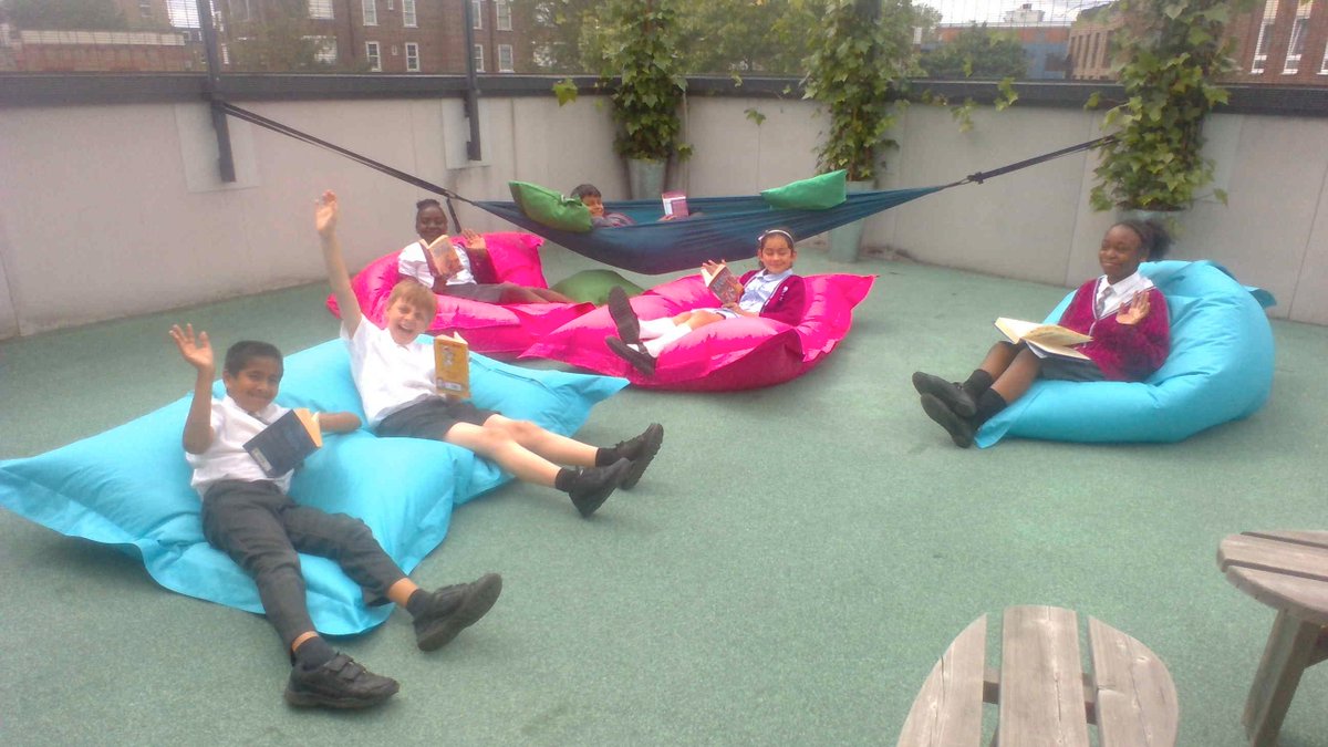 ArkBrunel's tweet photo. Year 5 making the most of the good weather on our top floor terrace at lunchtime today. Bliss! #headinabook #heartofBrunel https://t.co/l6LR92IfY2