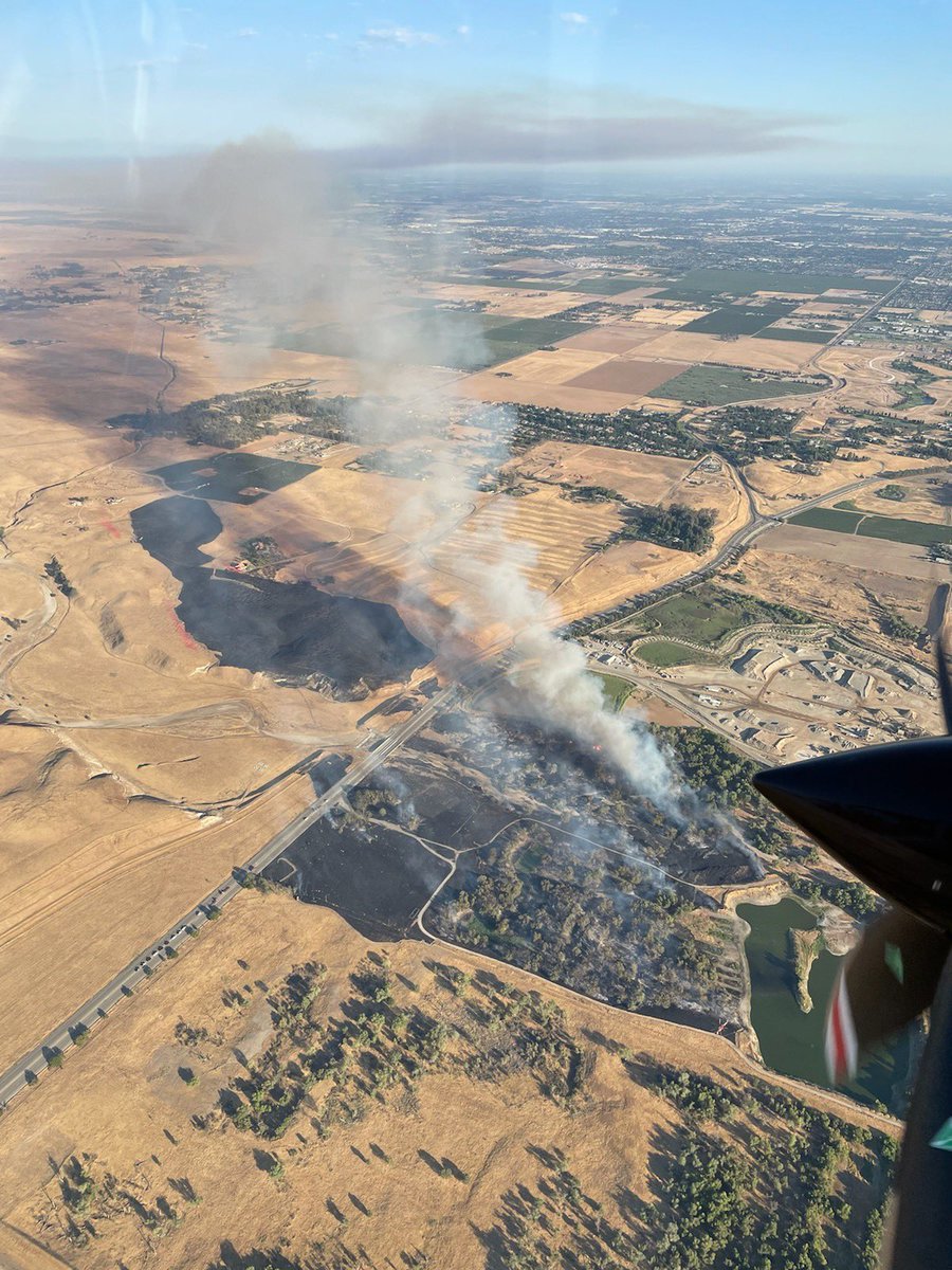 FresnoCoFire's tweet photo. #VulcanFire [Update] Firefighters are making progress stopping the wildland fire, N Friant Rd x N Willow Rd, NE Fresno. The fire is 125 acres, forward progress slowed/stopped to the east and west, helicopters/ground crews gaining upper hand. No structures involved, no injuries. https://t.co/23bmXYVmXx