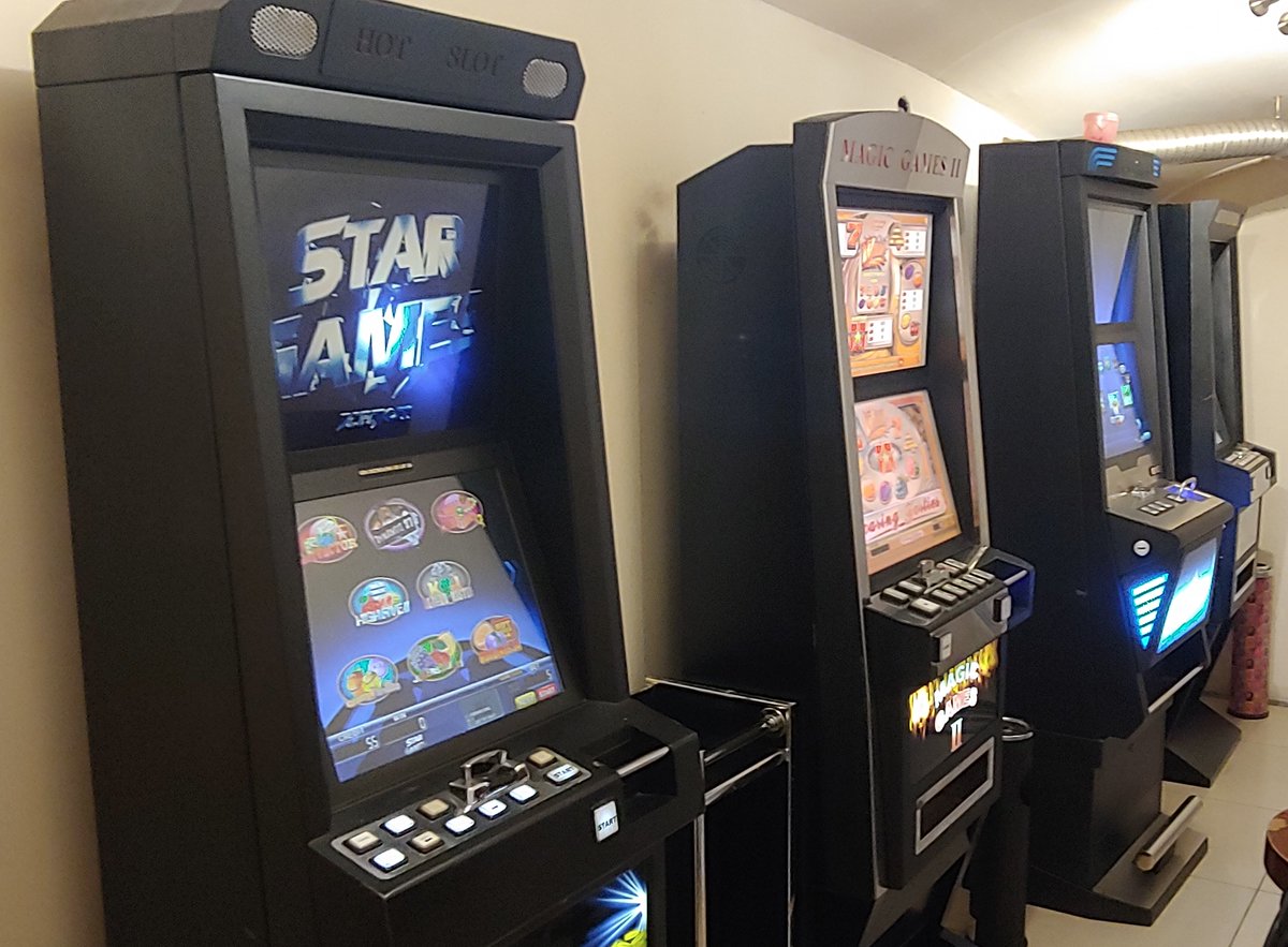 Cztery czynne automaty do gier wzdłuż jasnej ściany.