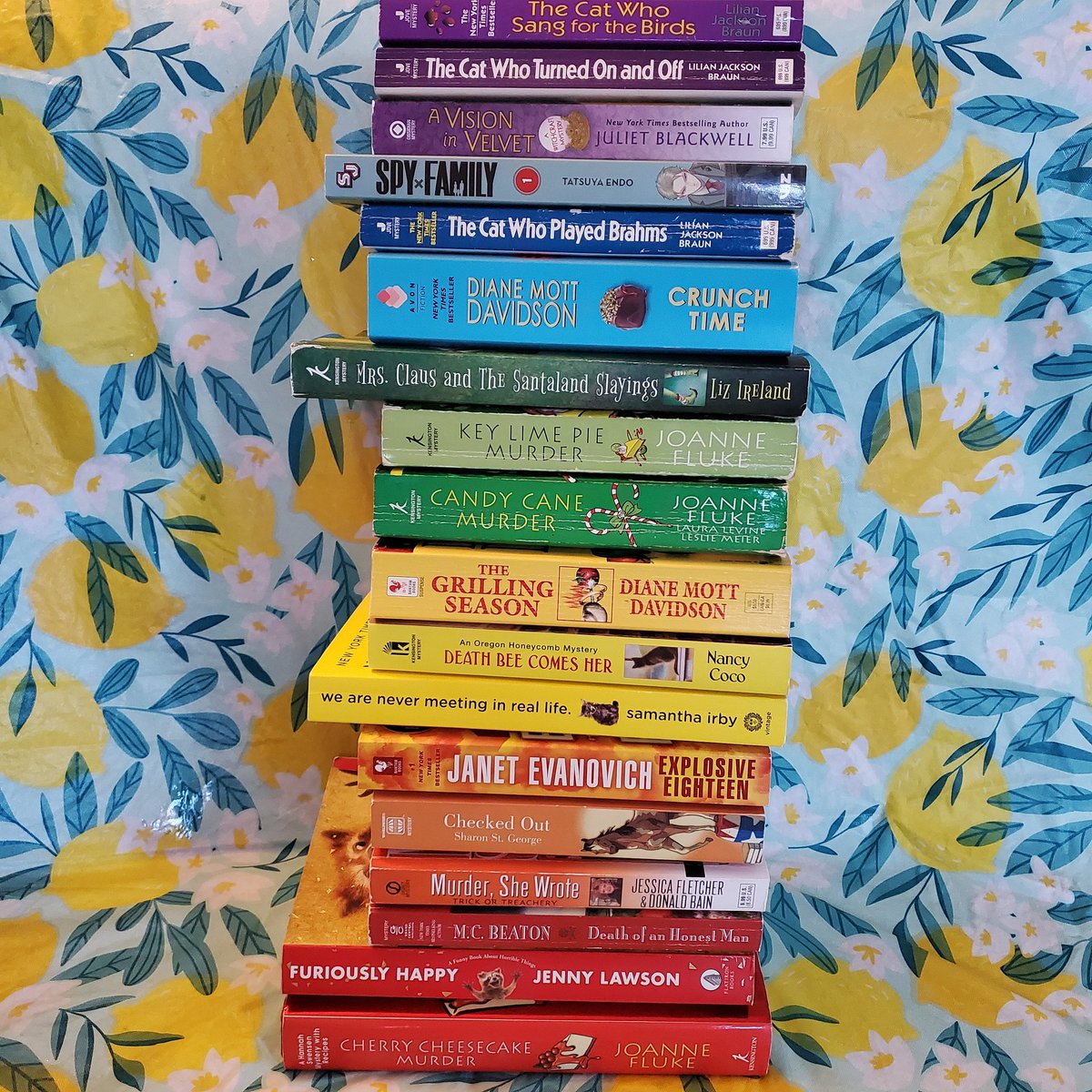 I love a good #rainbowbookstack I think it's obvious by this #bookstack that I'm slightly #obsessed with #cozymysteries what's your favorite #bookgenre or #favoriteauthor