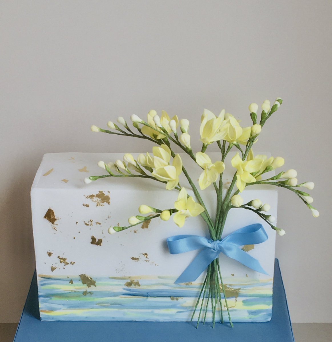 Handmade sugar freesia flowers, hand painted blues, yellows and edible gold leaf. #handpaintedcake #ediblegoldleaf #handmade #sugarflowers #craft #freesia #birthdaycake #porshamcakes #custom   #bespoke #50thbirthdaycake #50thcake #dartmoor #devon