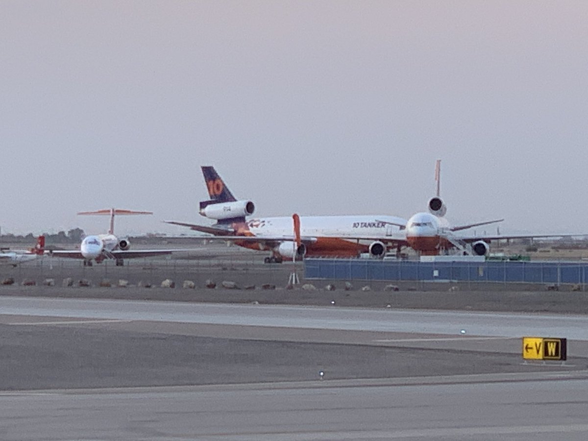 TysonOnTV's tweet image. The sun rises an angry red as seen from @gatewayairport. Air attack planes on the tarmac ahead of what will be a critical day in the firefight against the #BackboneFire