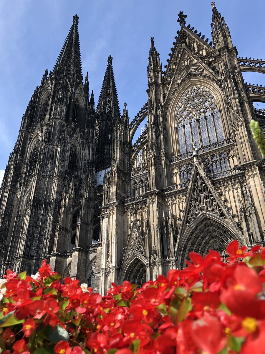 ドイツ幻想風景 赤い花の咲く花壇から見上げたケルン大聖堂 あの日は雨模様ながら 時折真っ青な晴れ間が見えた夏の日 そろそろ 夏本番なので 青空を背に観光地の写真を撮りに行きたいですね この望みが叶うものなら 縦長写真で見せたかったドイツ
