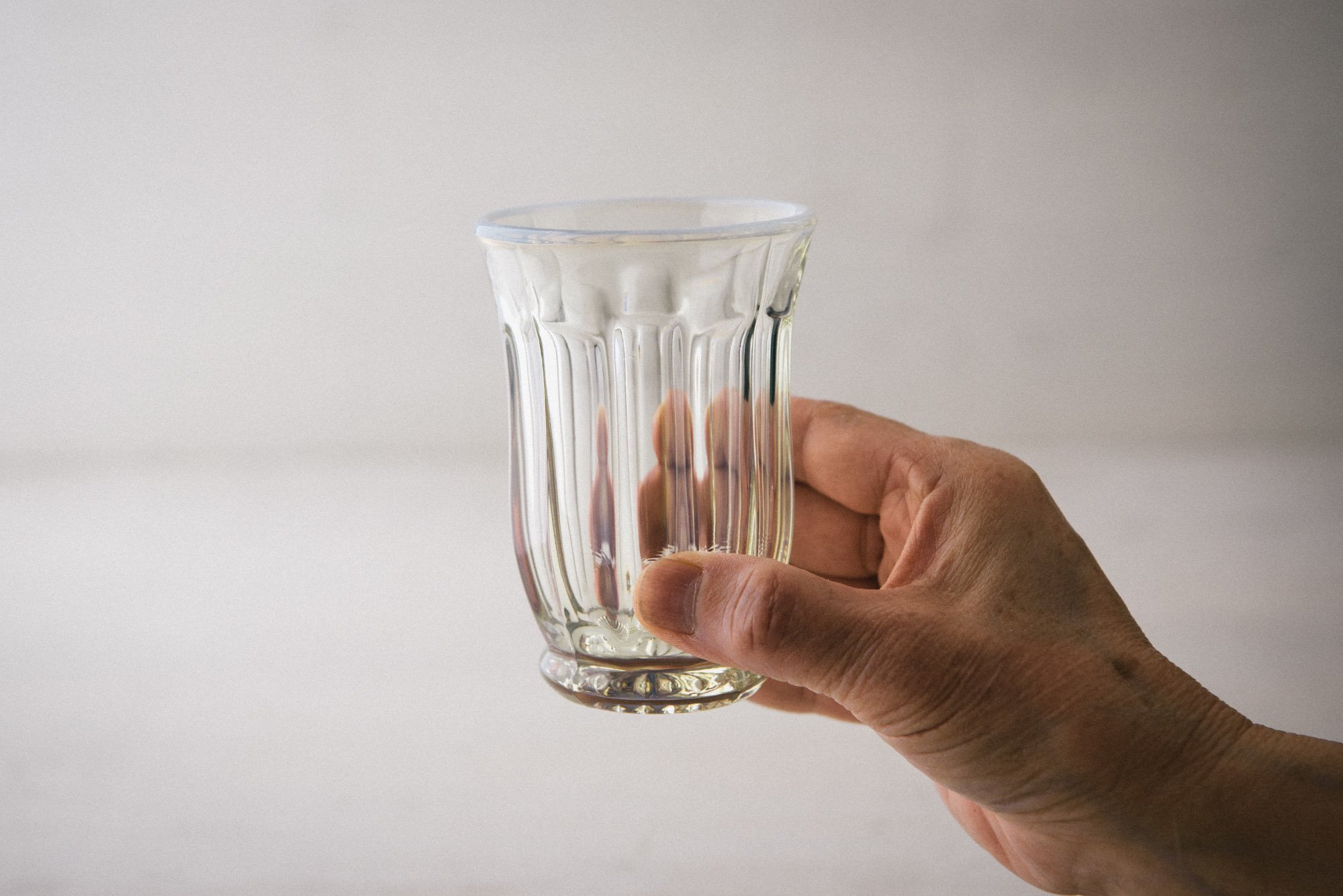 わざわざ コーヒーをいれてアイスを浮かべたい レトロで涼しげなガラスの器 廣田硝子さんの古代色 雪の花シリーズ タンブラーです 全体的に波を打ったような模様がほどこされ ふちは淡雪を降らせたような白いふち取りになっています これからの季節