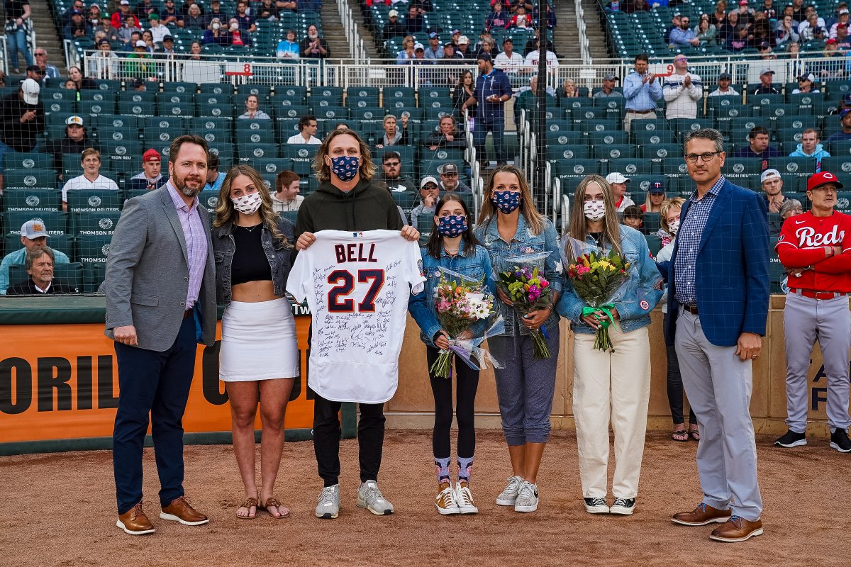 Twins's tweet photo. We honor our late bench coach Mike Bell as we take on the Reds, managed by his brother David. The Bell family was presented with Mike's 2020 jersey signed by the team and a donation to Gigi’s Playhouse. Mike's wife Kelly threw out the first pitch. Tonight we play for Mike! ❤💙 https://t.co/GtlAy42dDU