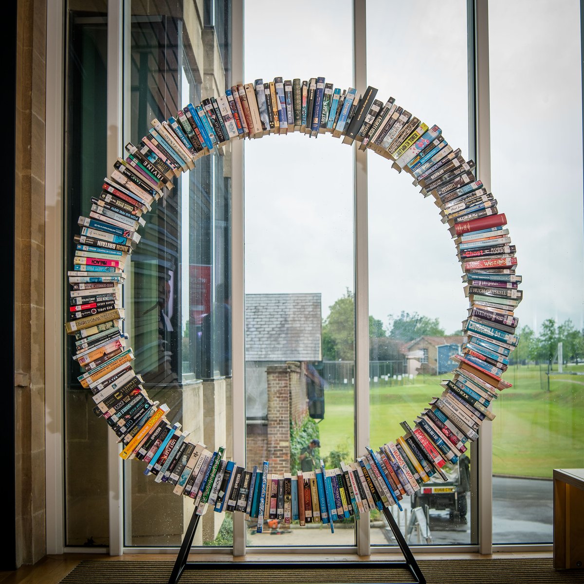 TonbridgeUK's tweet photo. A recent addition to the School's Library is this wonderful Wheel of Books, created by Will Biddle (Housemaster and DT Teacher) for the entrance way. It is nearly seven feet tall, contains 270 real books, took many months to create and is proving to be quite a talking point! 📚 https://t.co/SZhAwaMow1