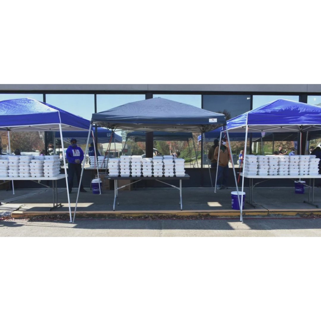 3 tents on the sidewalk of a storefront standing over to-go food boxes