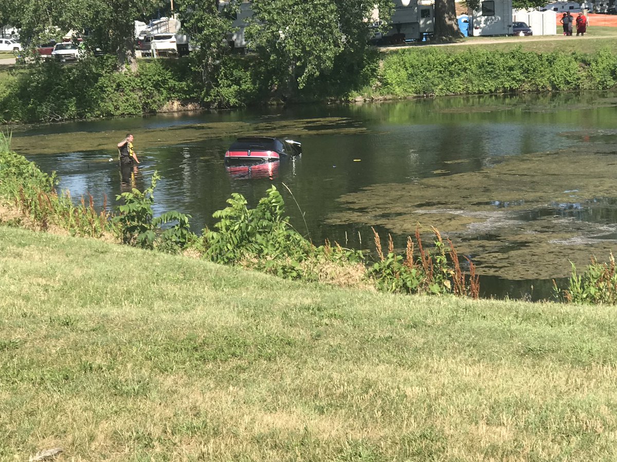 A vehicle is partially submerged in one of the lagoons at Greater Ottumwa Park. Paramedics are examining the driver at the scene.