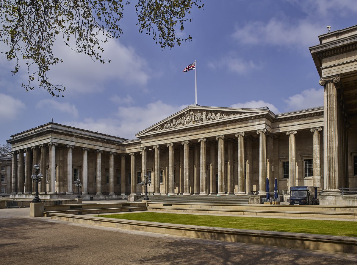 The frontage of the Museum showing the colonnade and pediment under a blue sky.