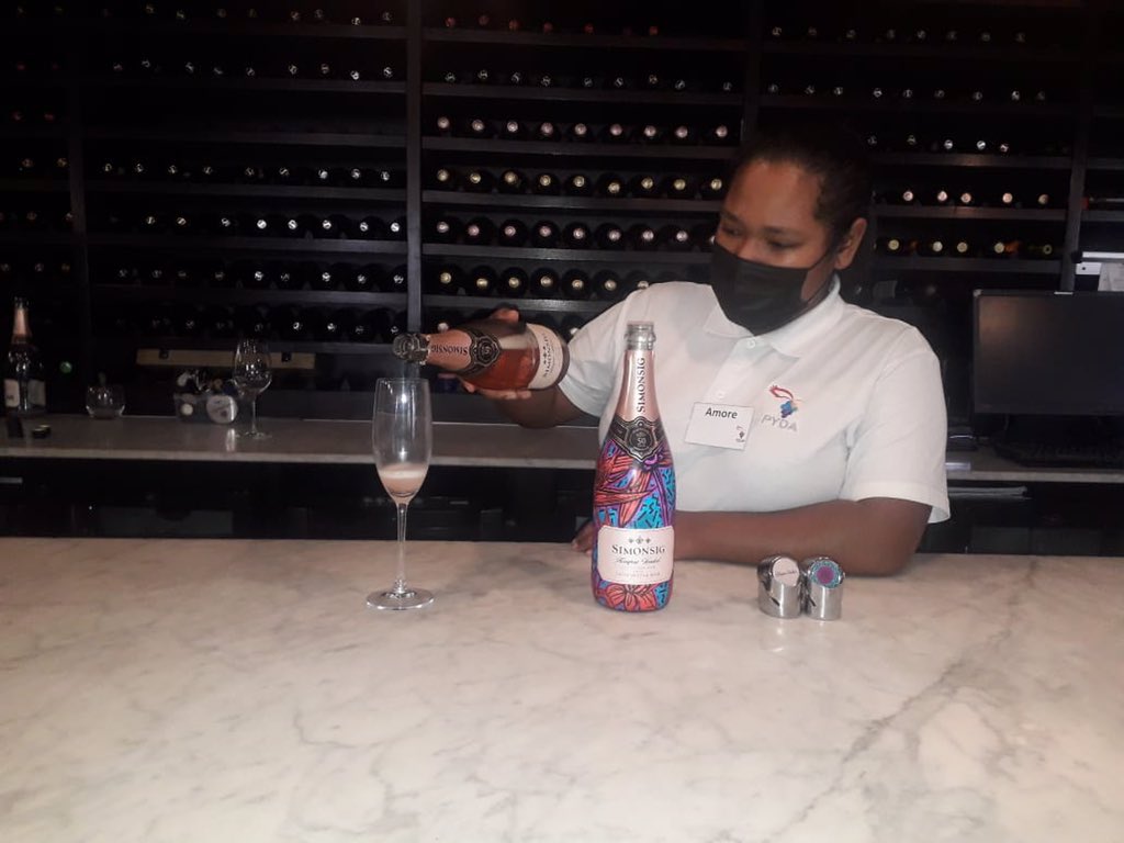 PYDAcademy's tweet photo. Amore Ras looks right at home, pouring bubbly and serving guests. She’s @SimonsigWines, home of Kaapse Vonkel, South Africaʼs first Méthode Cap Classique. It’s the sparkle in her eyes for us! 🤩🎊🇿🇦
#workplacement #workworld #practical #learning https://t.co/Mybu5P0oOn