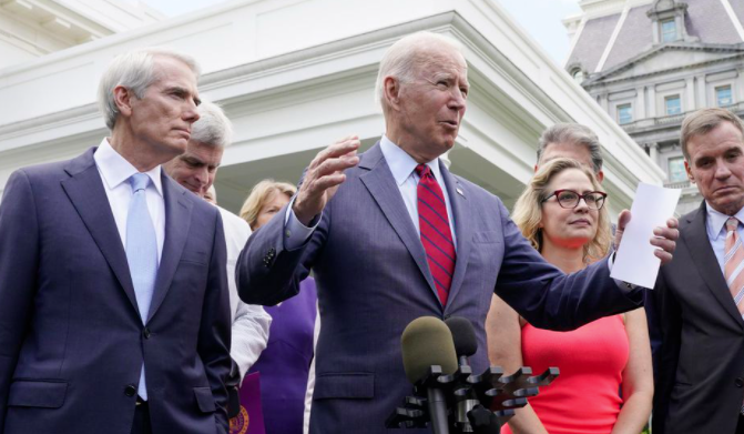 Forbes's tweet photo. A tweaked infrastructure plan keeps funds for Biden's EV chargers, trains, cleans buses https://t.co/hNijFxX3mQ https://t.co/h5lp9aJ2Wz