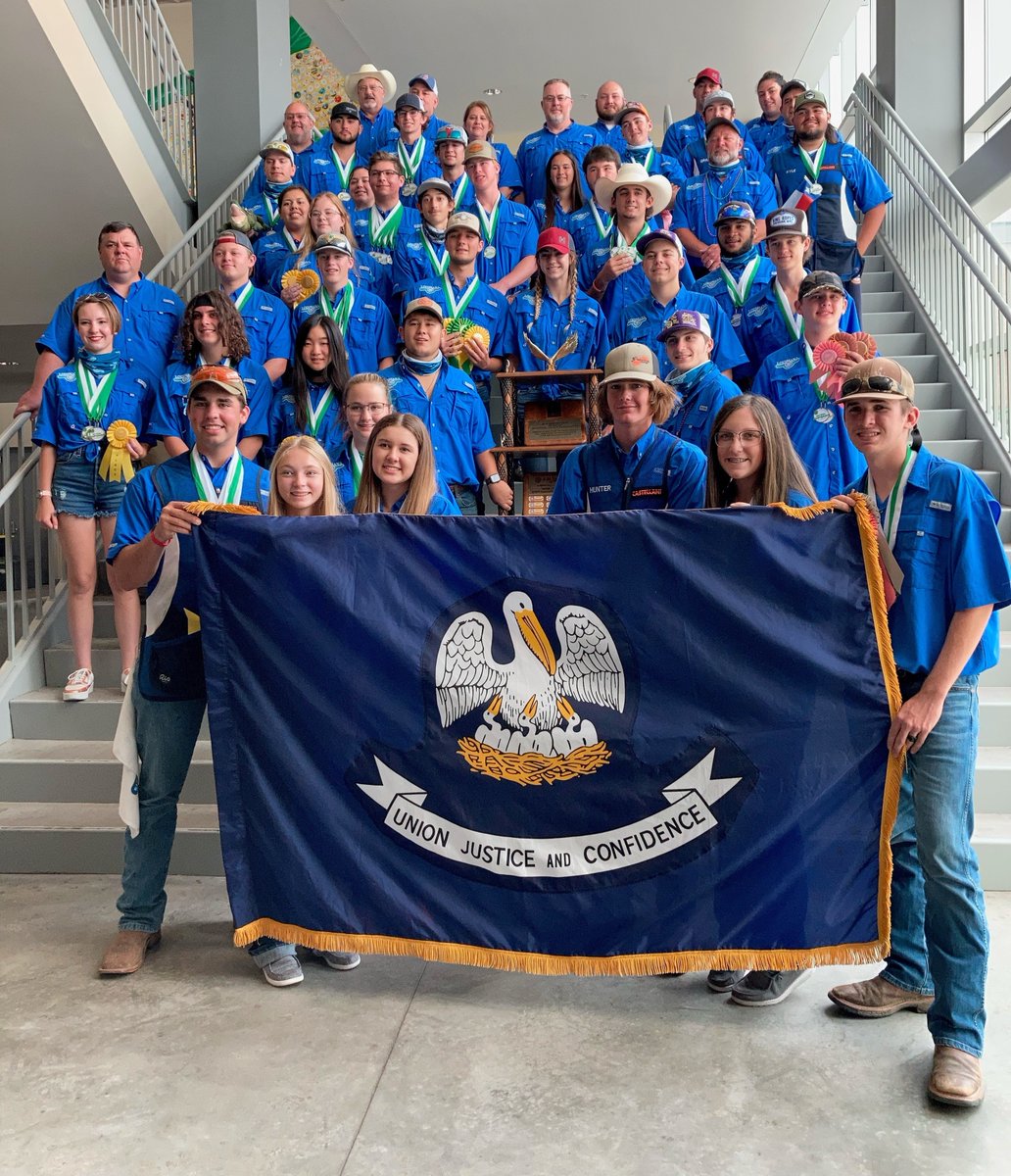 Louisiana 4-H Shooting Sports team poses with trophy and Louisiana flag.