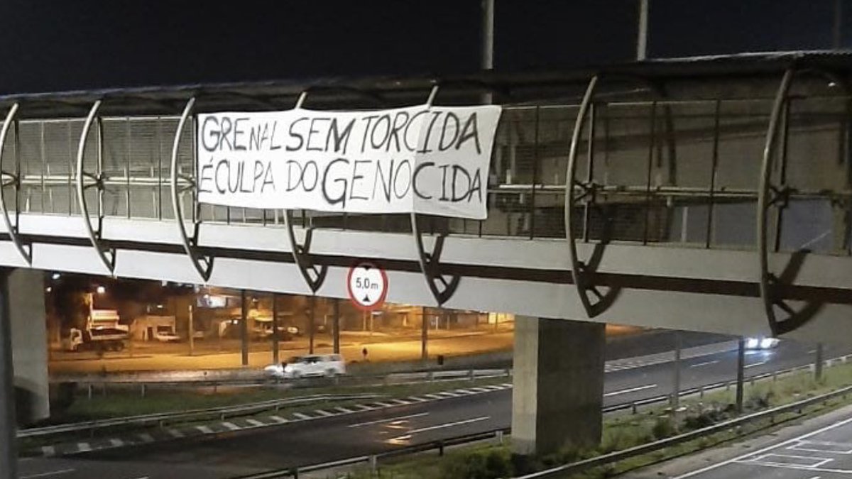 alexaguiarpoa's tweet photo. “Grenal sem torcida é culpa do genocida”. Faixa de protesto colocada em uma das vias do passeio de moto de @jairbolsonaro por Porto Alegre e região metropolitana. https://t.co/vf6kejKaXC